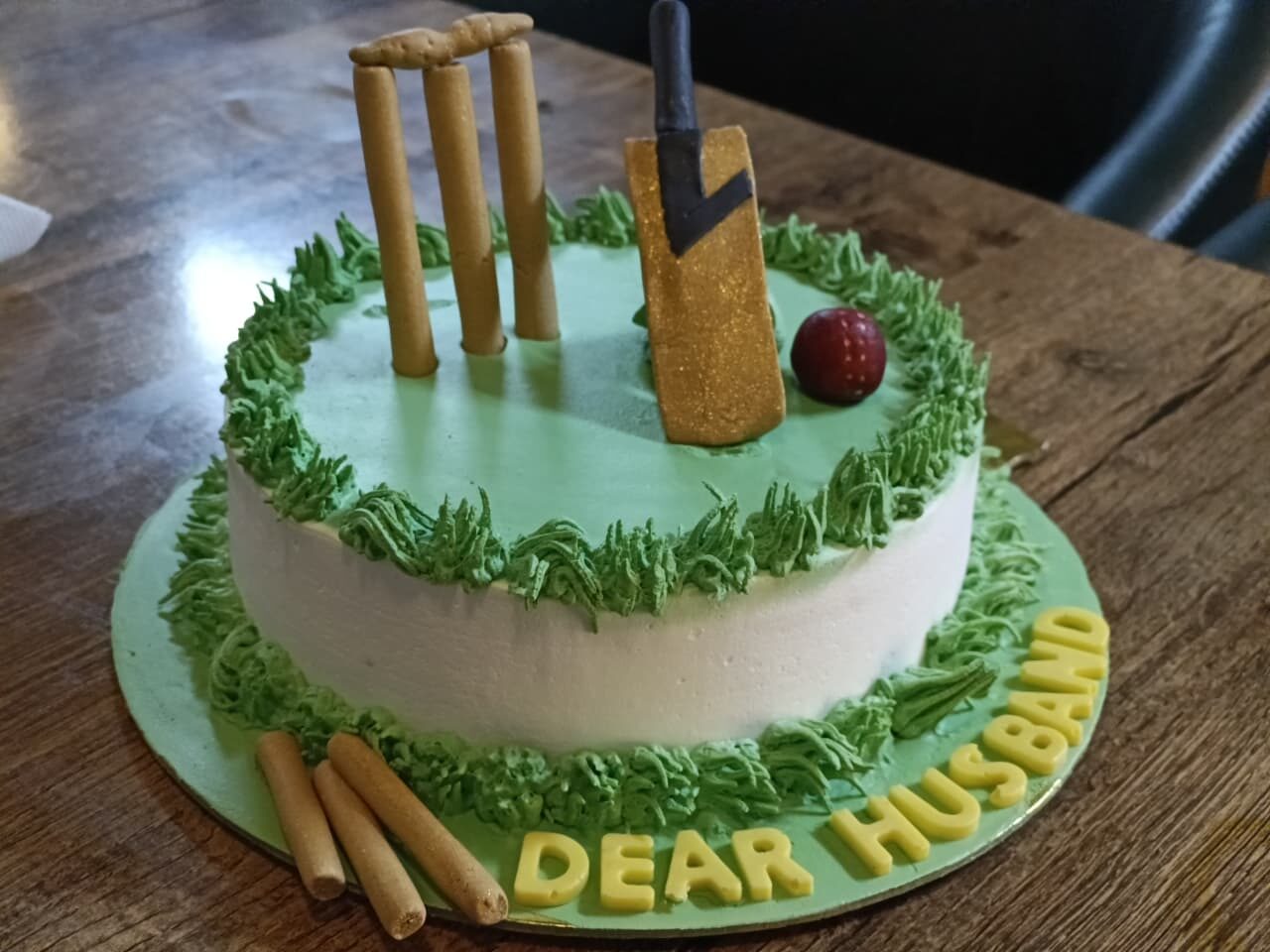 Cricket-themed cake with edible bat, ball and stumps