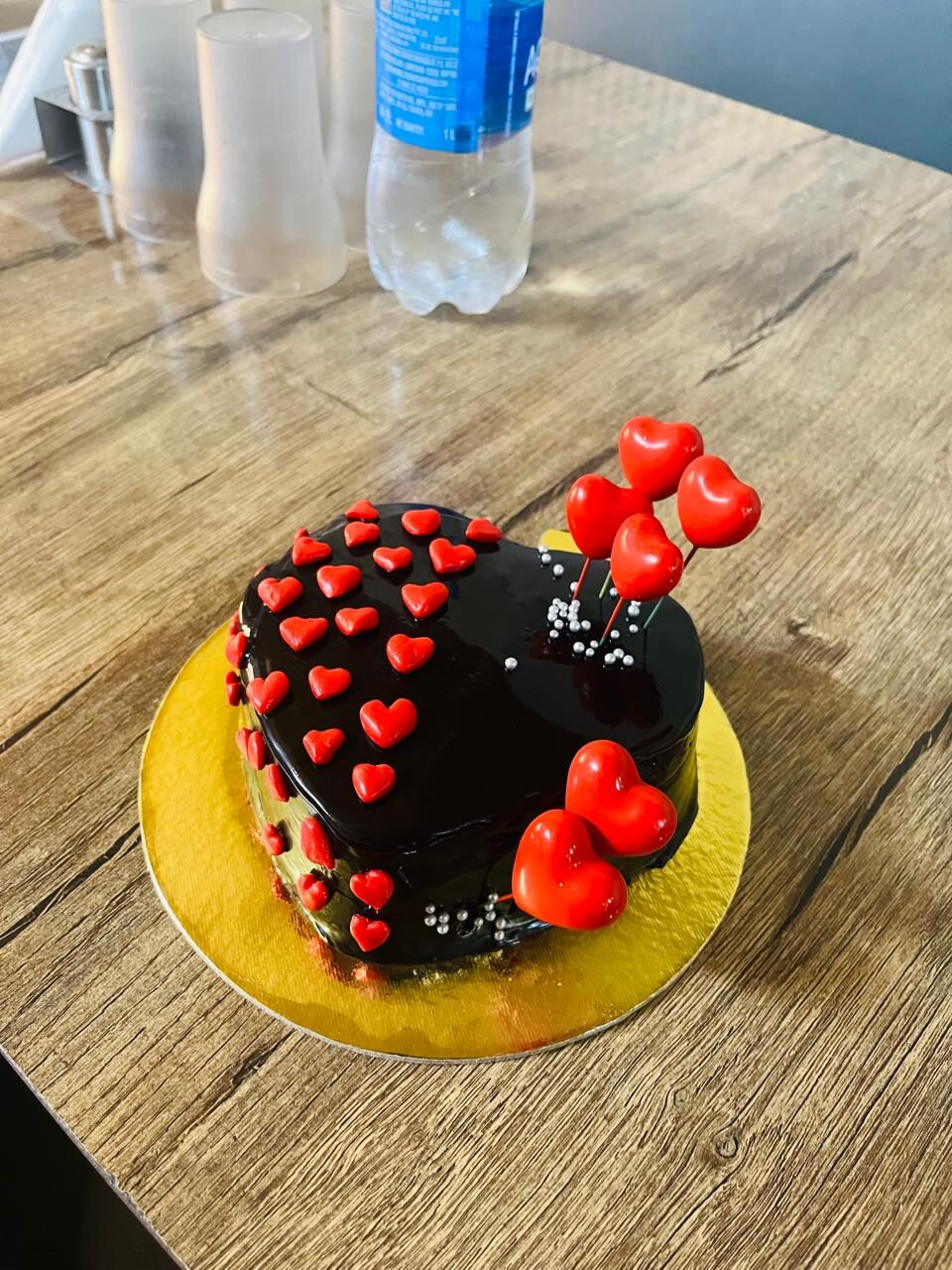 Heart-shaped chocolate cake with red heart decorations