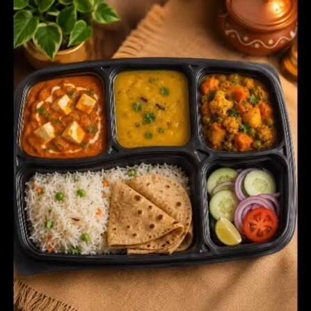 Indian thali with paneer curry, dal, mixed vegetable sabzi, rice, roti and salad